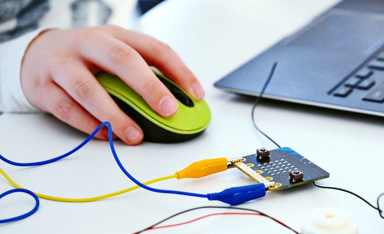 A boy's hand holding a computer mouse