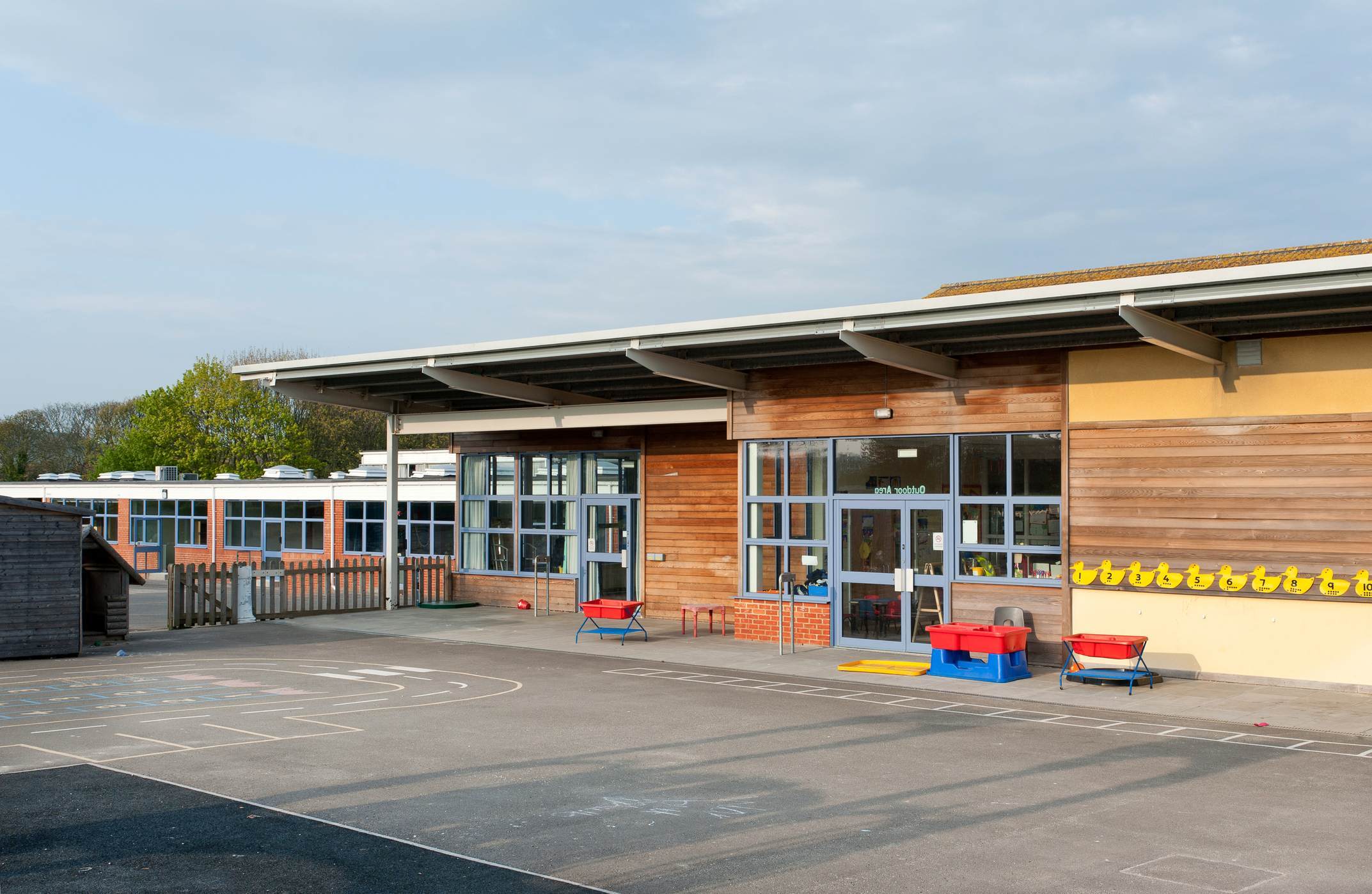 A modern school with wood wall and an empty playground.