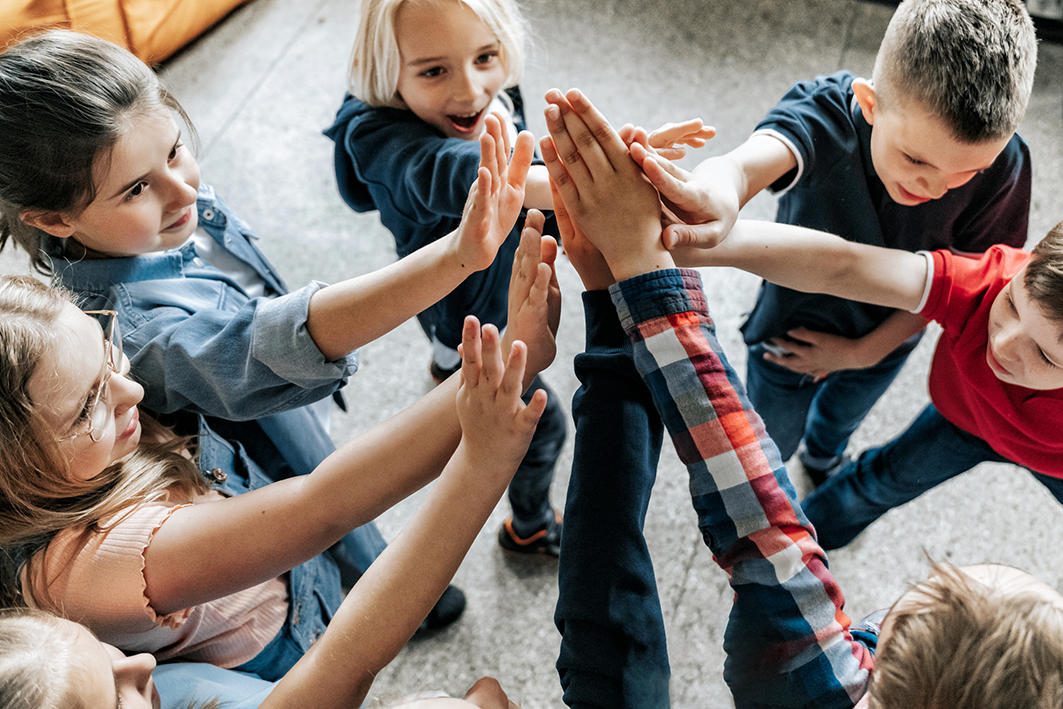 Group of children giving each other high fives in a playful activity.