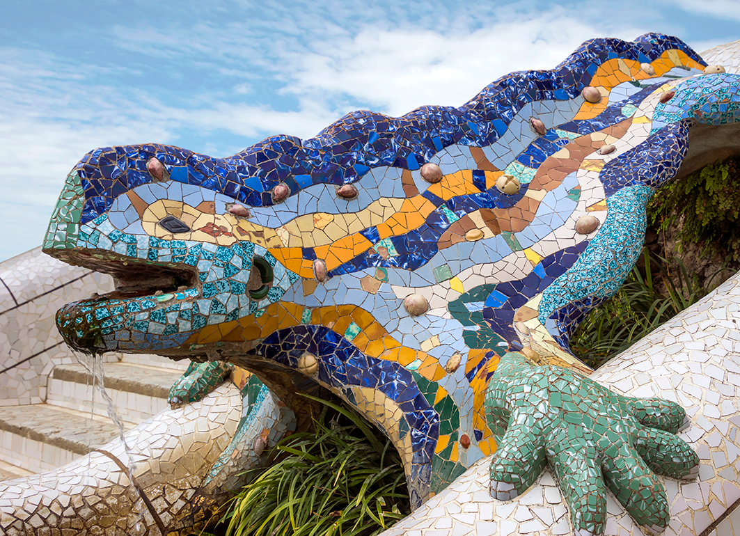 A colourful mosaic lizard sculpture with vibrant blue, green, yellow, and orange tiles.