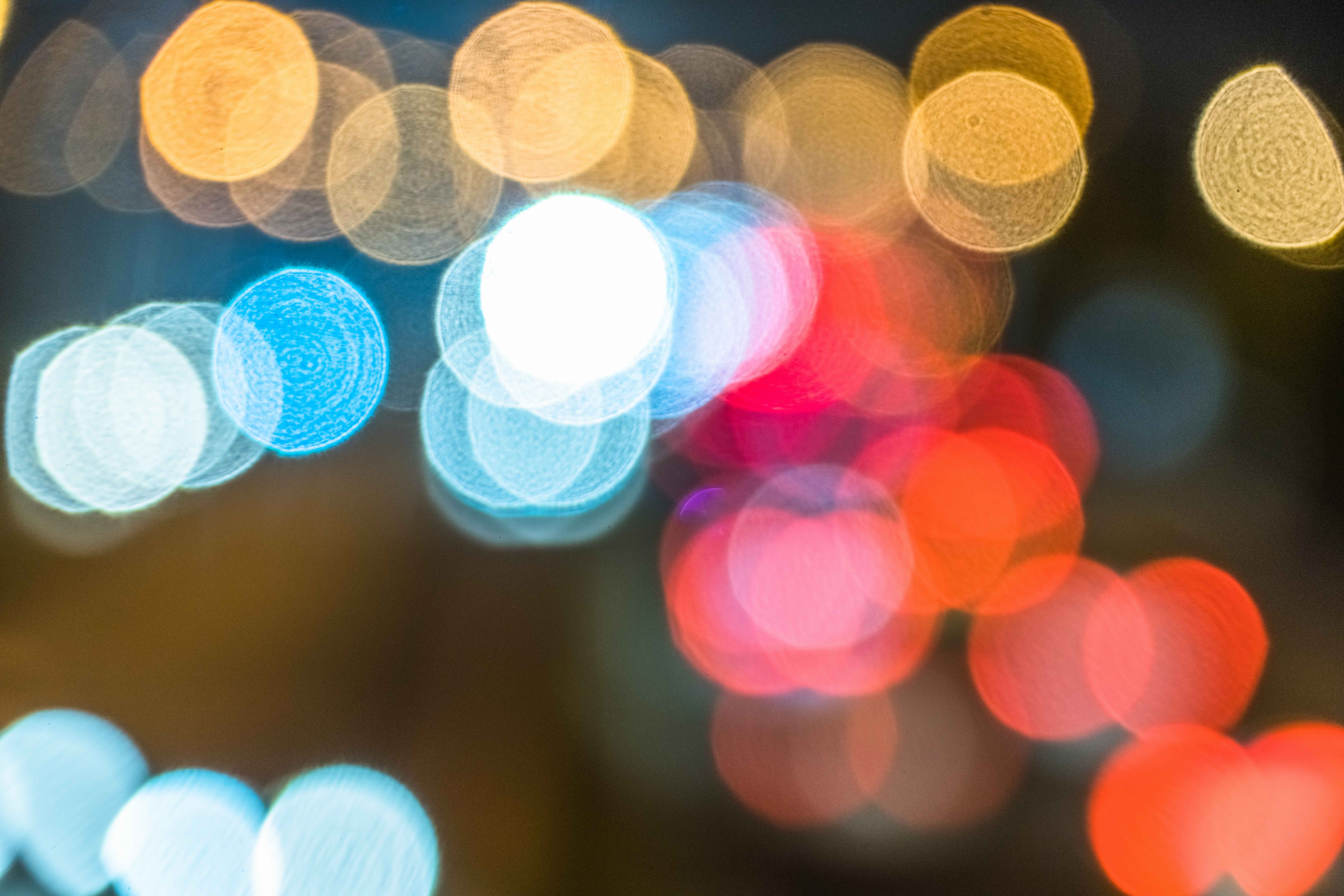Abstract image with blurred circles of different coloured lights, creating a bokeh effect.