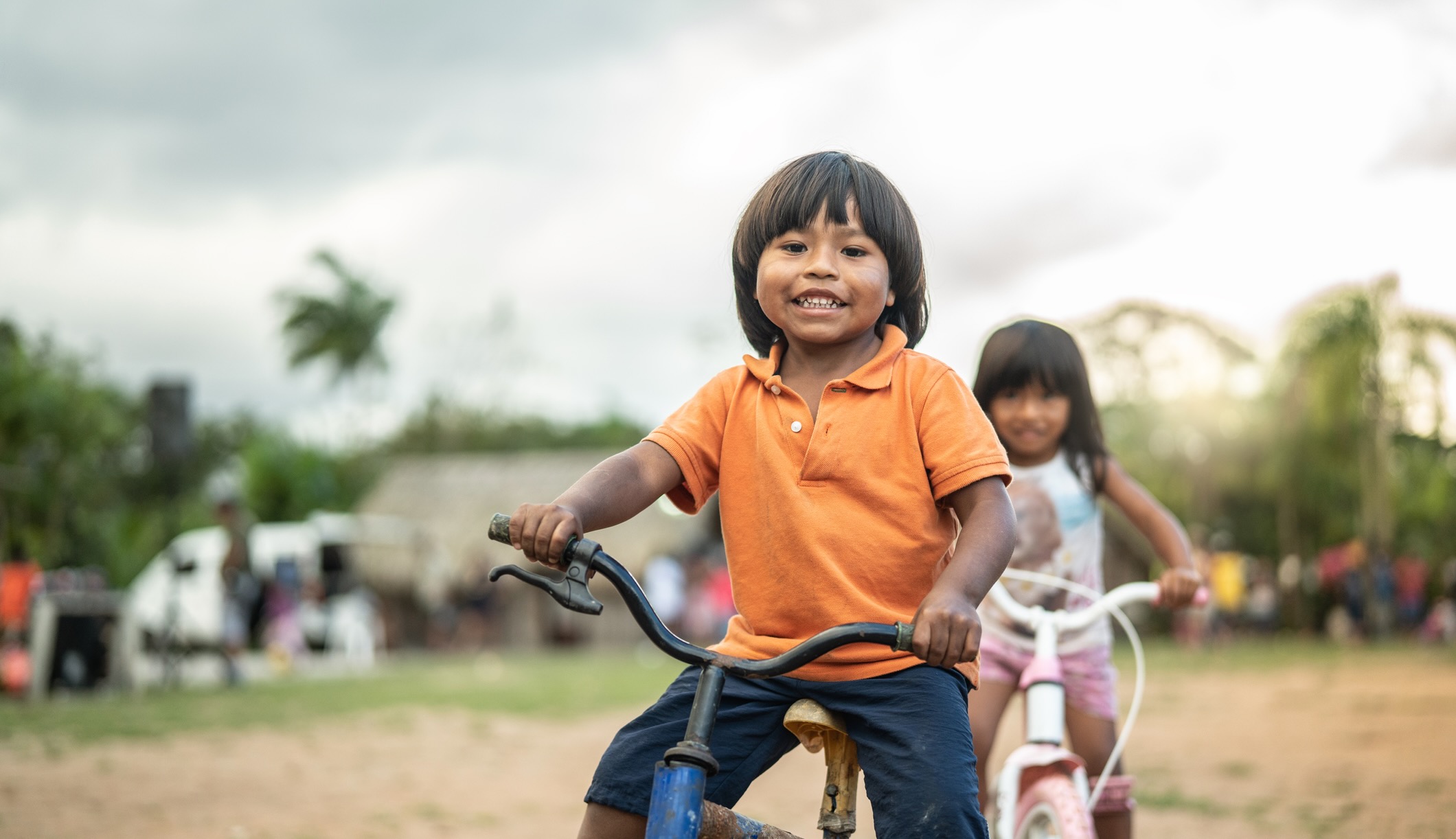 Two Children Riding a Bicycle in a Rural Place