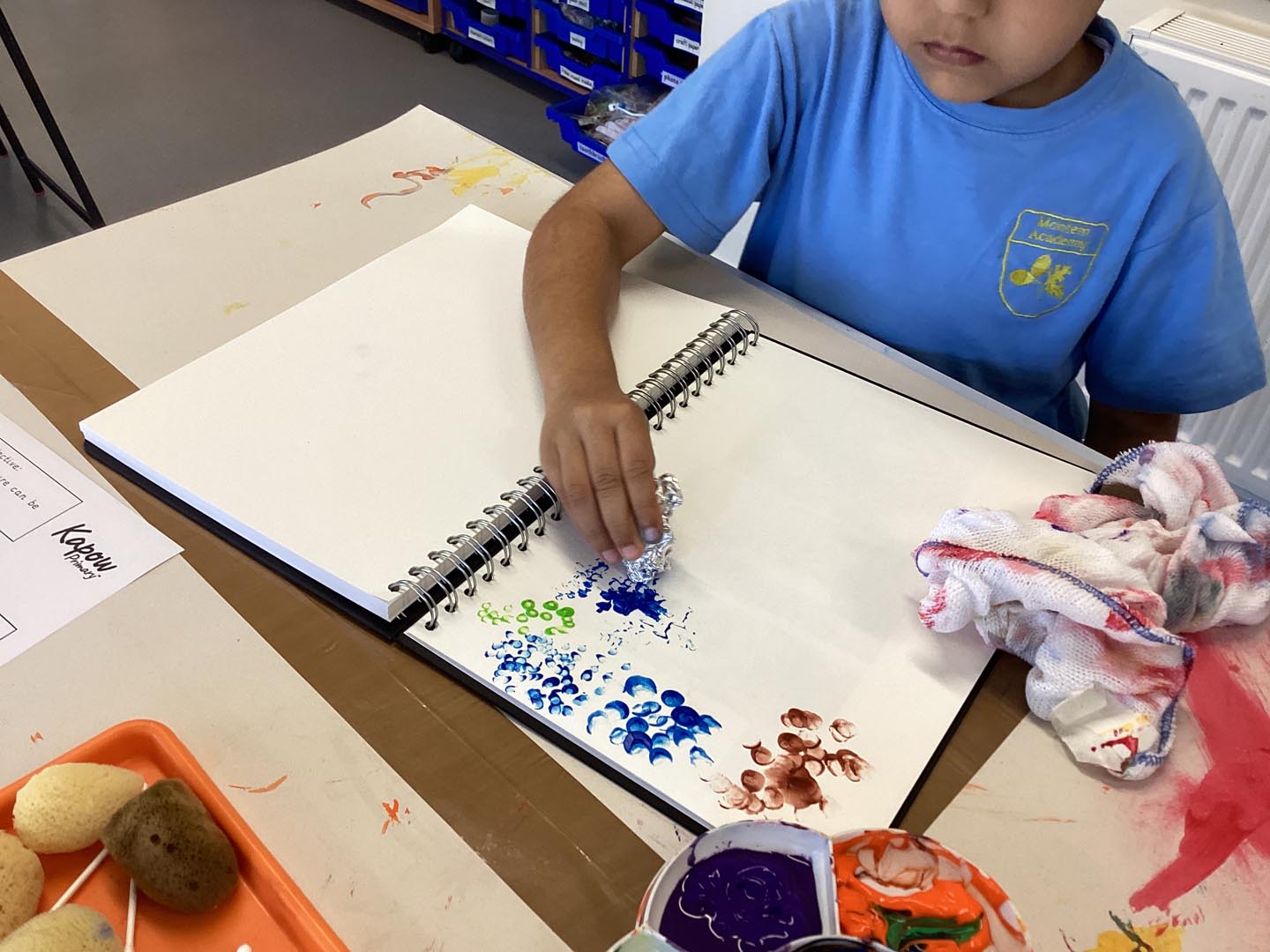 Child making textures with paint by dabbing