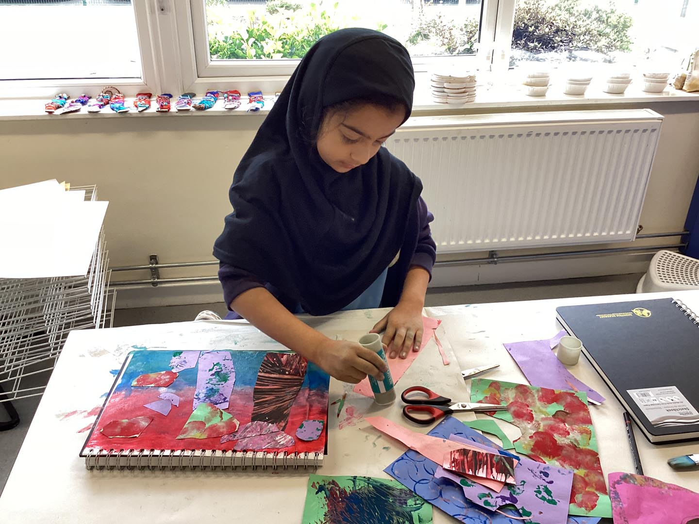 Child creating a collage picture using papers