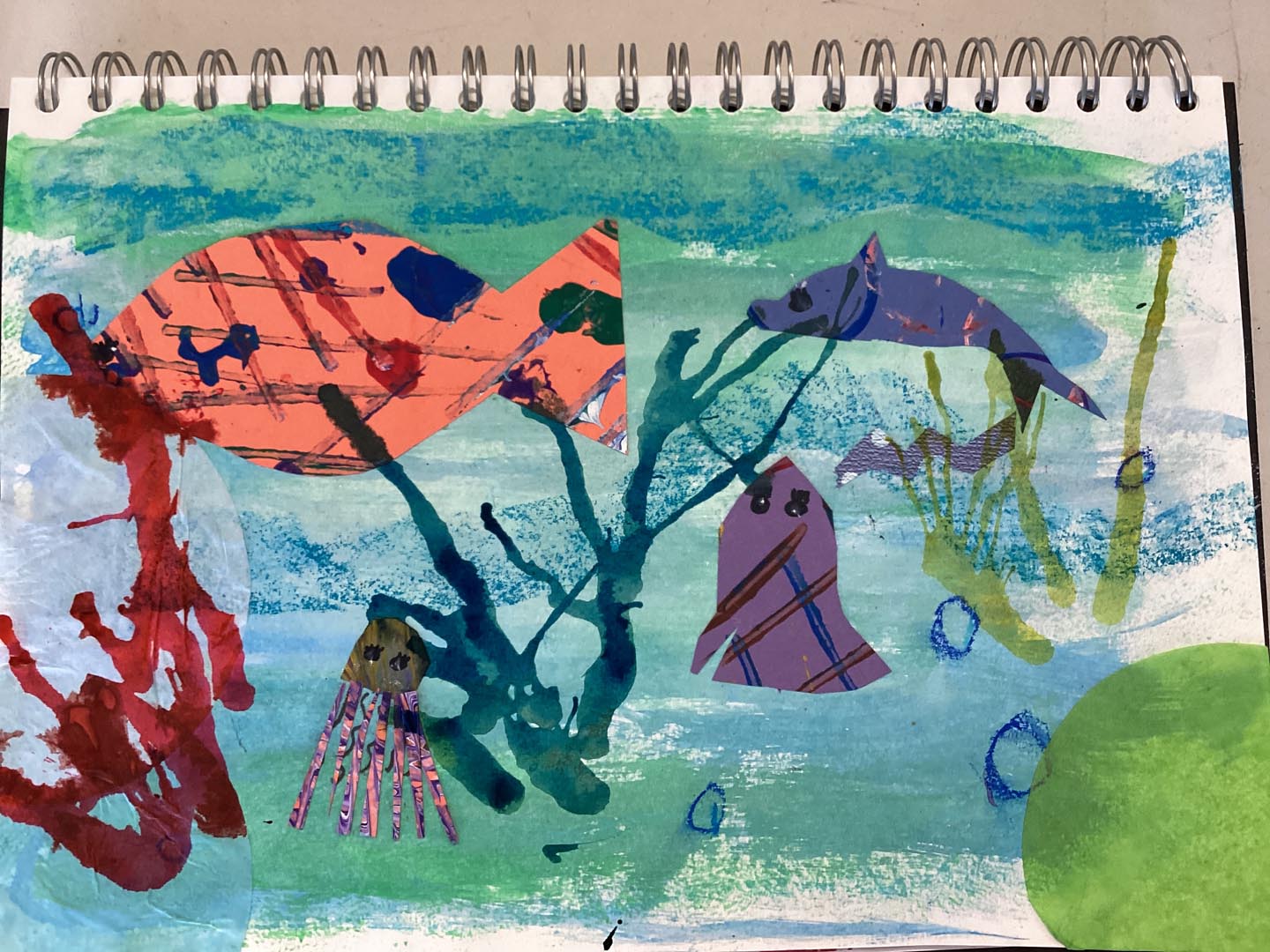 Child created collage using painted textured papers with a sea theme