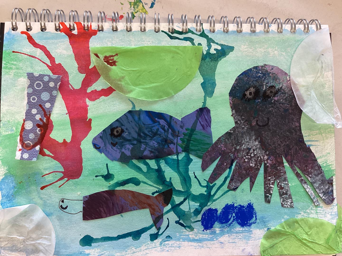 Child created collage using painted textured papers with a sea theme