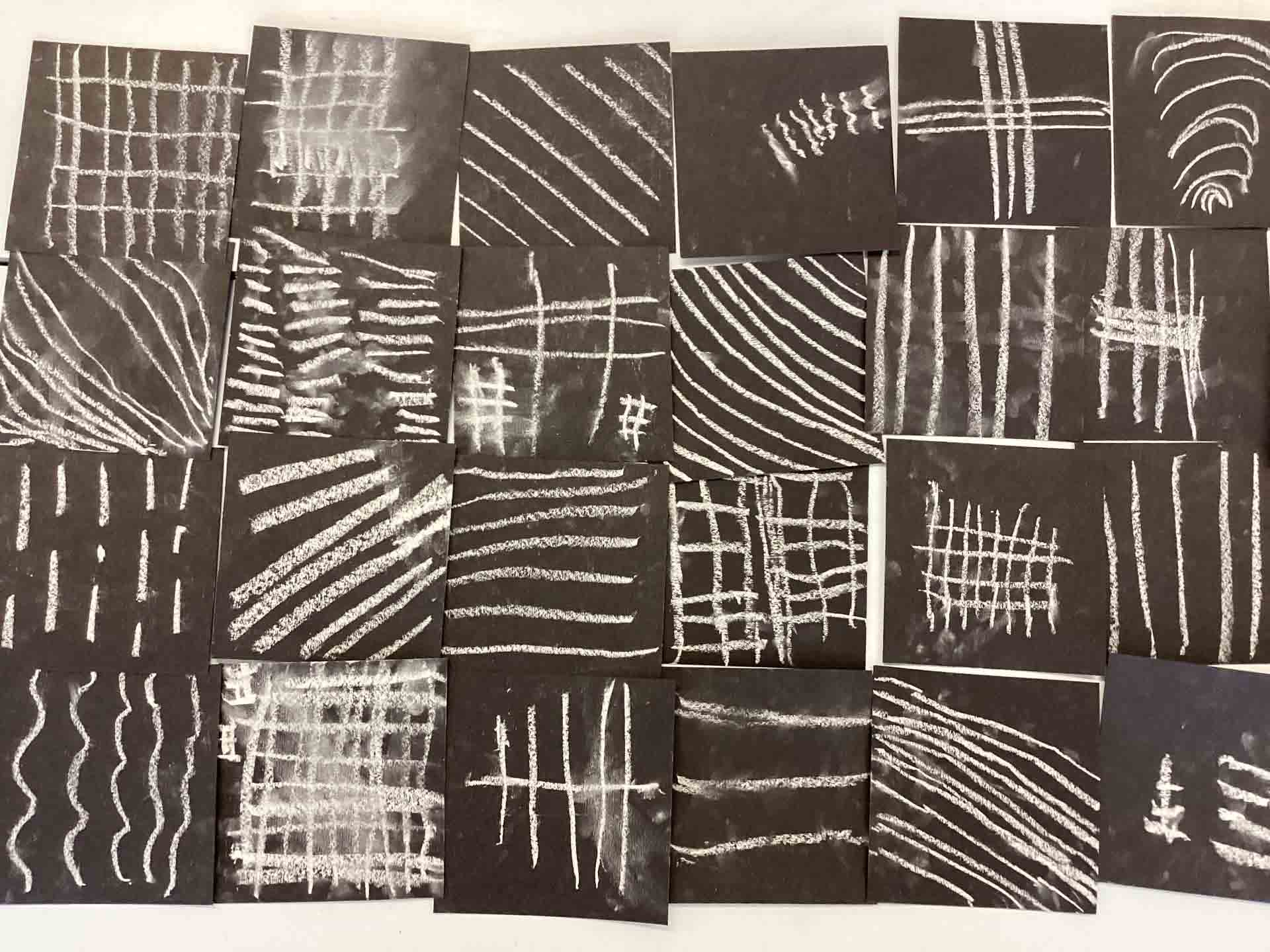 Year 1 Children's artwork; black paper squares with white chalk lines