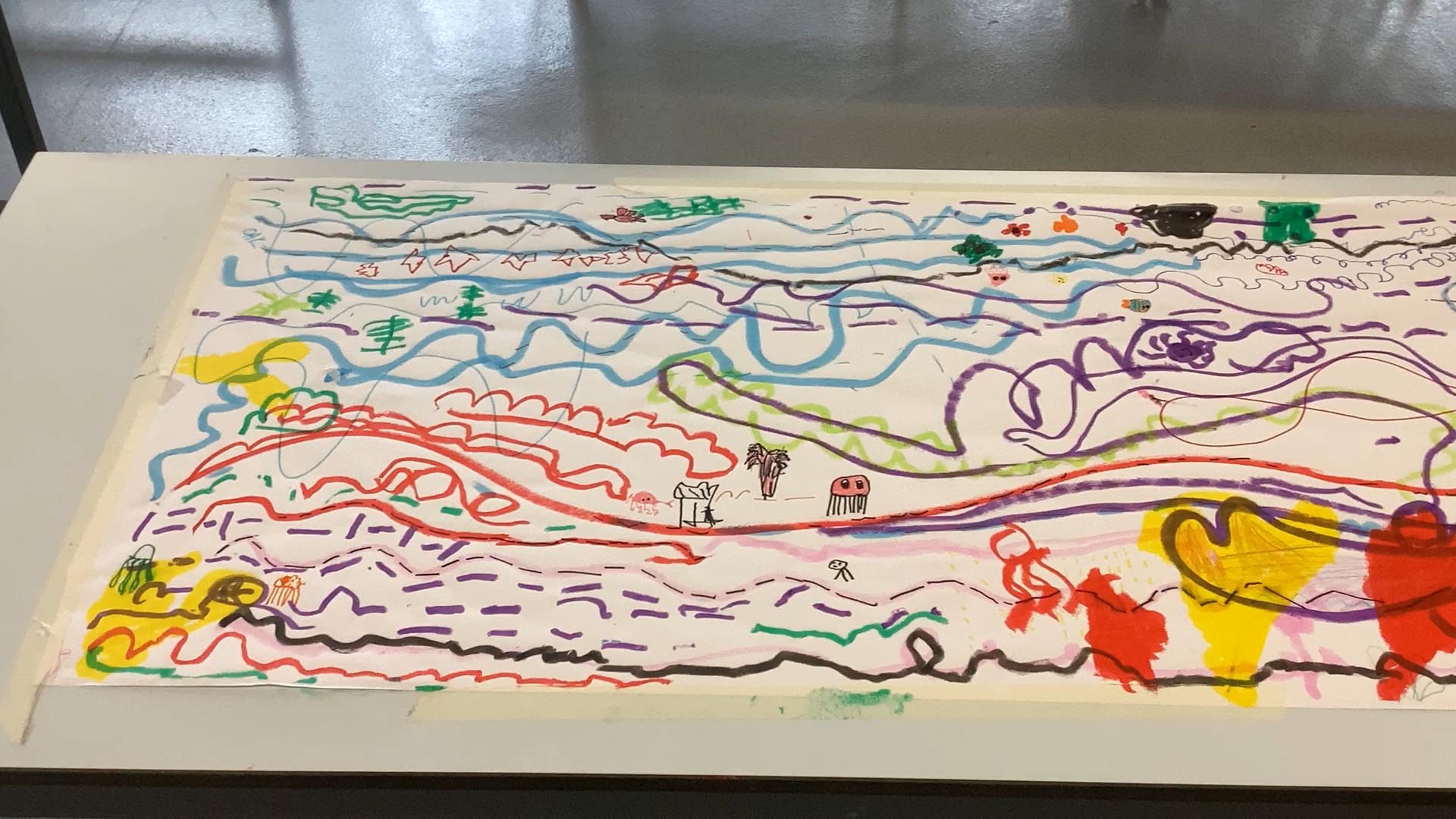 Long and large piece of paper with children's doodles of lines and shapes inspired by listening to music