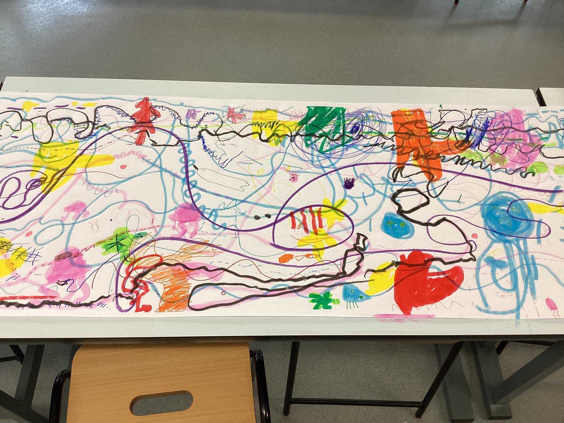 Long and large piece of paper with children's doodles of lines and shapes inspired by listening to music