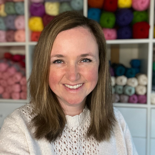 Content creator Suzanne smiling in front of a colourful background of yarn